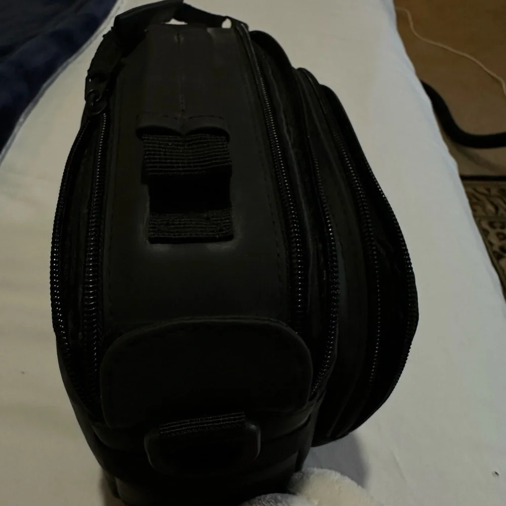 Canon black camera bag with zipper packets, and a handle at the top.